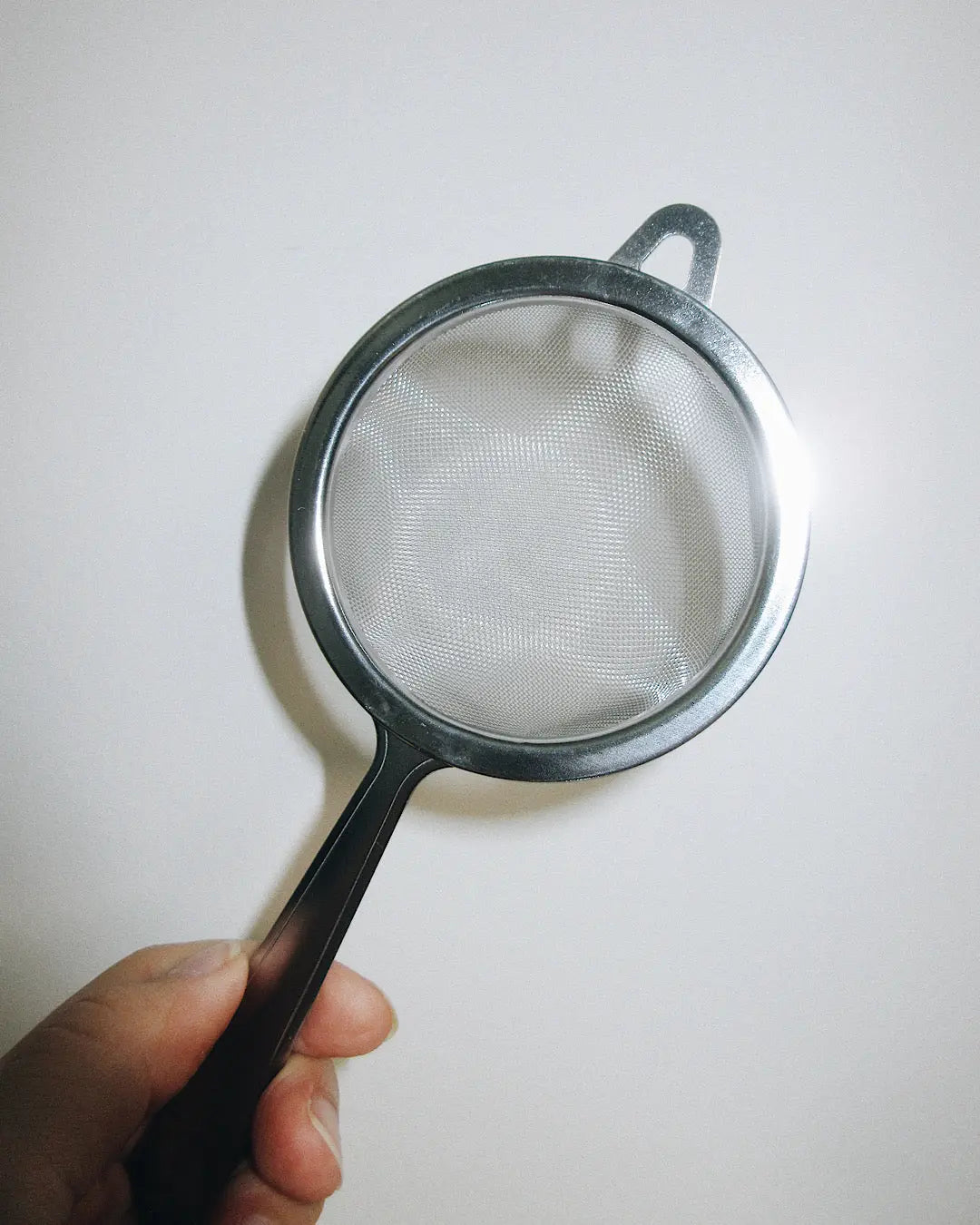 hand holding tea sifter | Romi Matcha