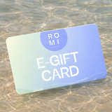 E-gift card with 'ROM' branding on a sandy surface