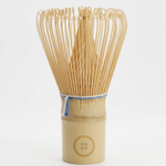 Bamboo whisk with a wooden handle on a white background