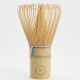 Bamboo whisk with a wooden handle on a white background