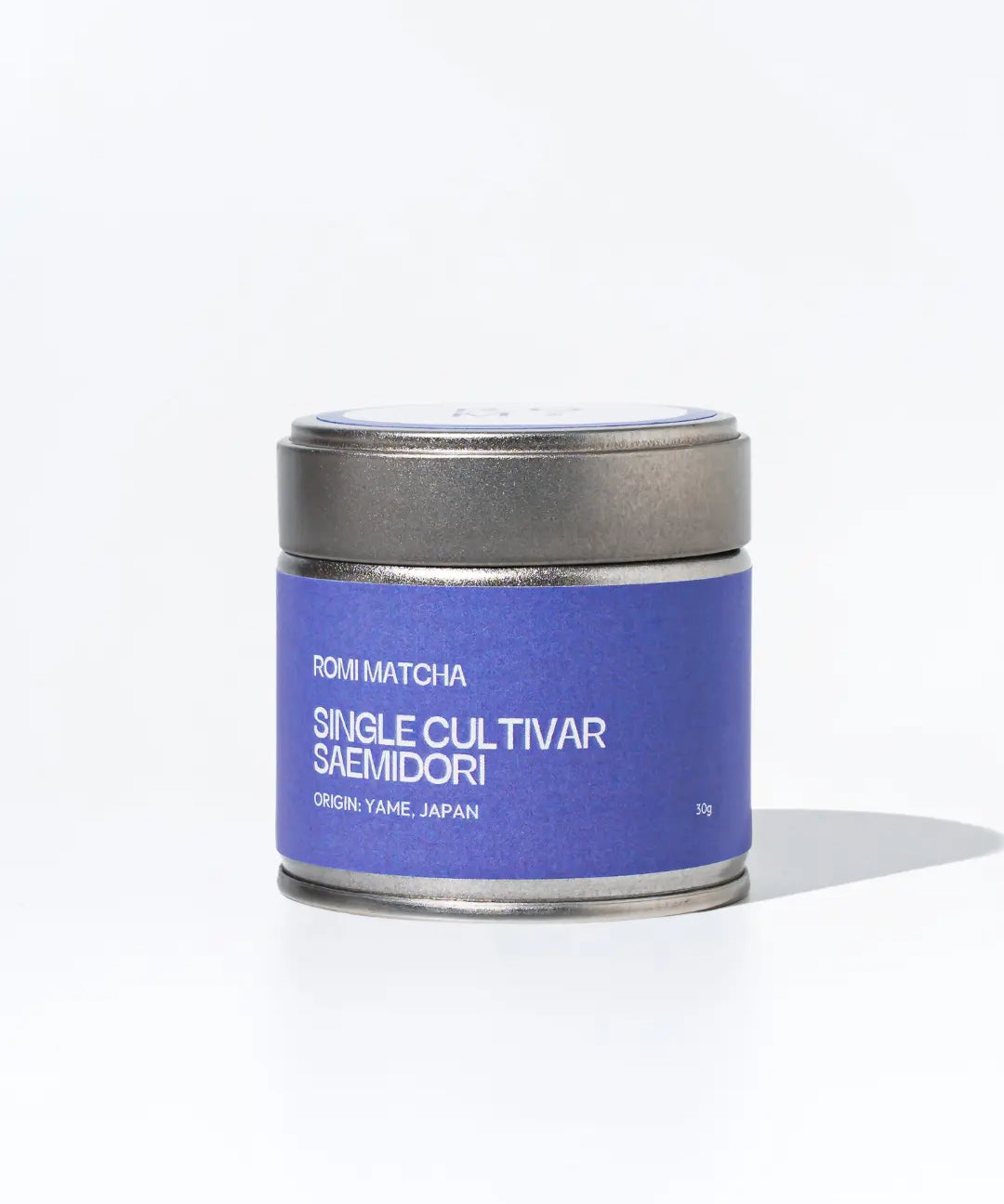 Matcha tea canister with purple label on a white background