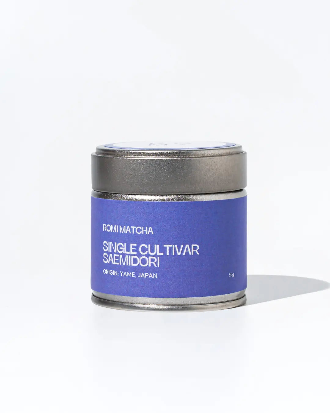 Matcha tea canister with purple label on a white background
